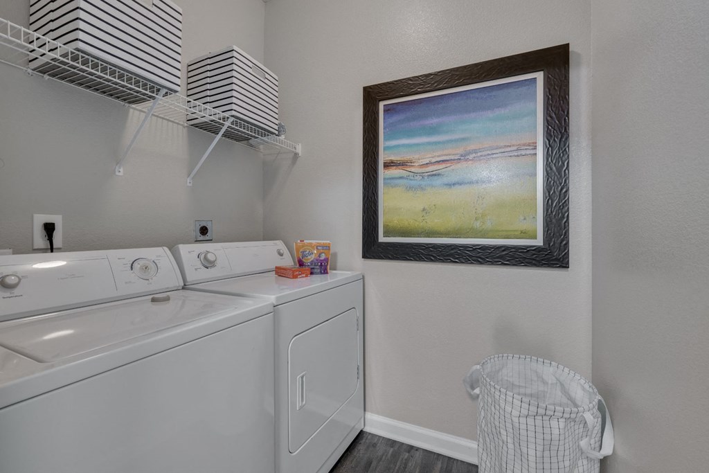 a washer and dryer in a laundry room with a painting on the wall
