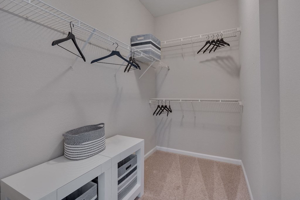 a closet with shelves and hooks and a table in a room with a white wall