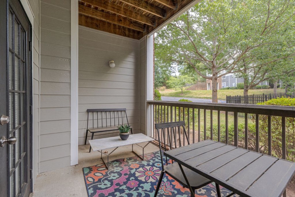 a covered patio with a table and two chairs on it