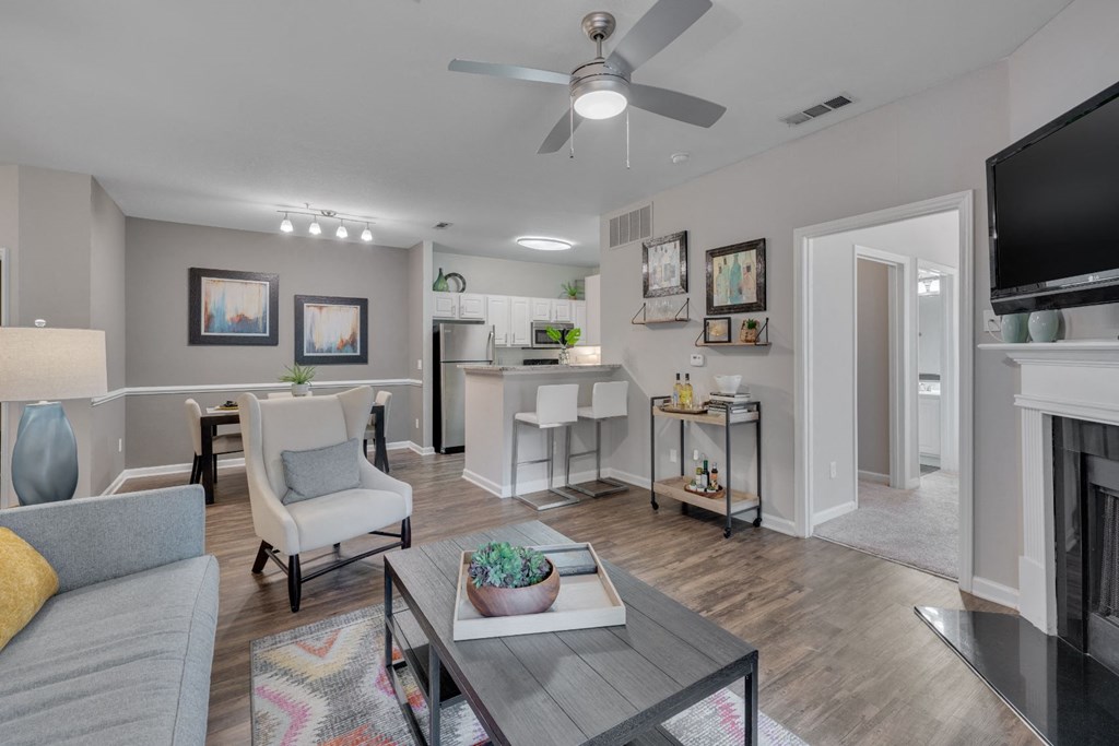 a living room with a ceiling fan and a dining room and a kitchen