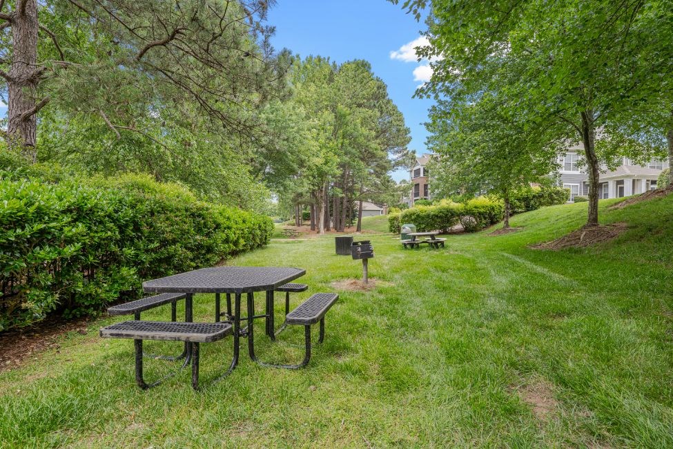 a park with picnic tables and benches in the grass