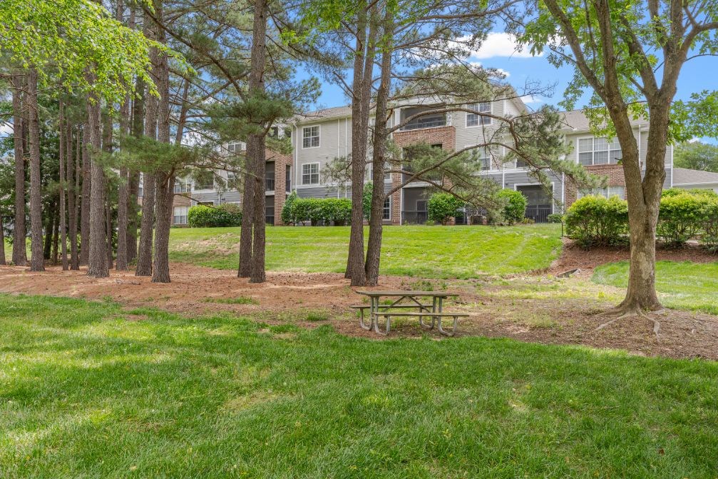 a picnic table in a park in front of an apartment building