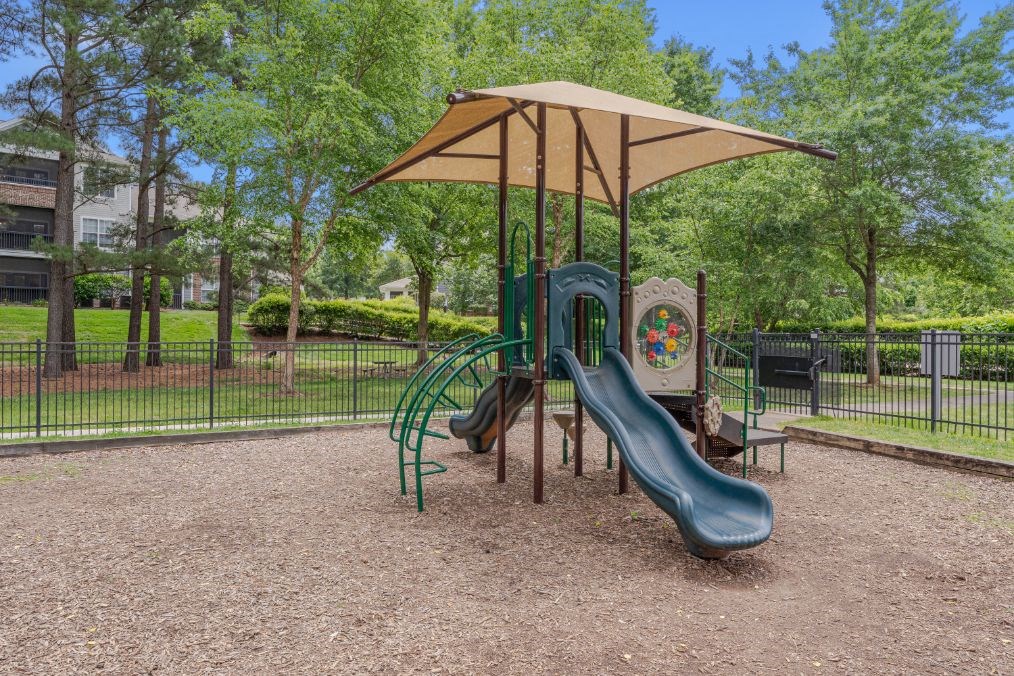 a playground with a slide and a umbrella