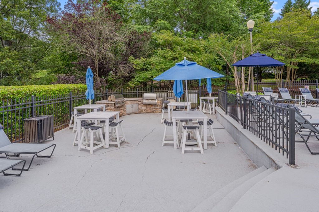 a patio with tables and chairs and umbrellas
