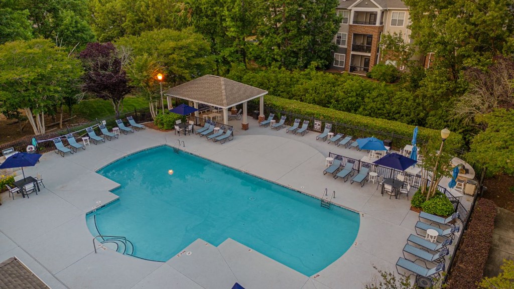 an aerial view of a swimming pool with chairs and umbrellas