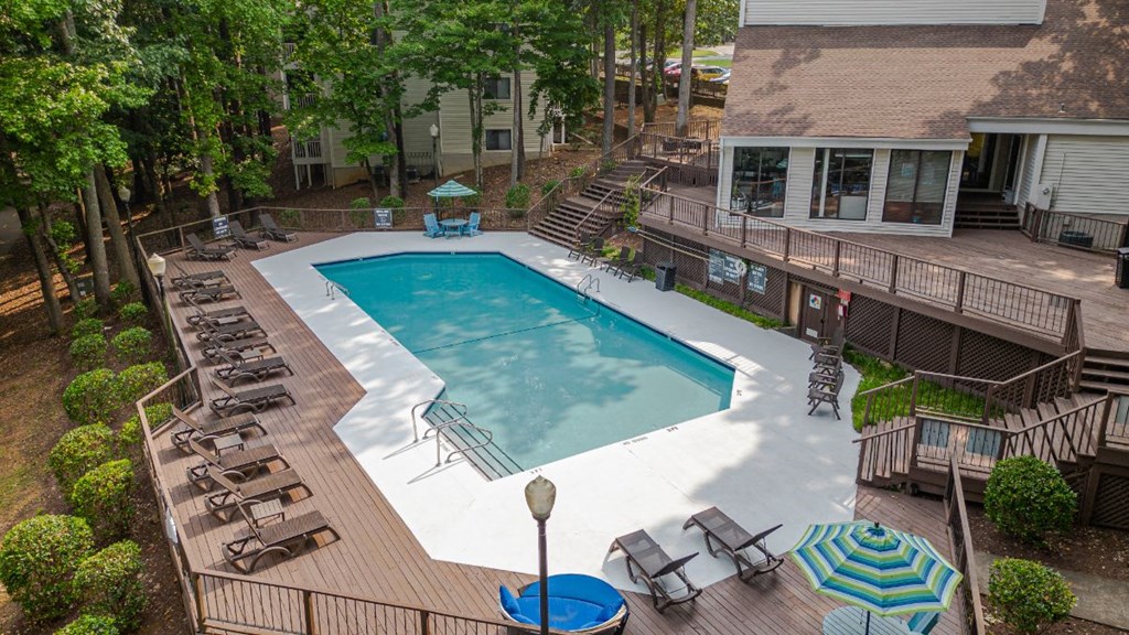 a swimming pool in a backyard with patio furniture