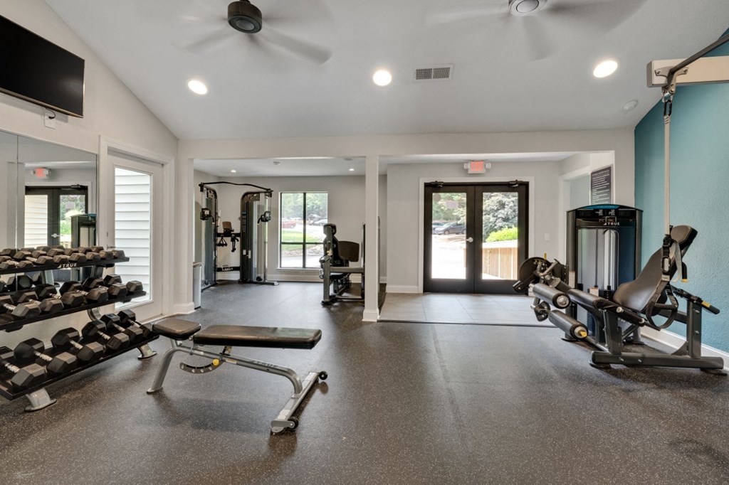 the gym has plenty of weights and cardio equipment and a door to the pool