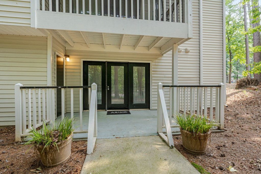 the front porch of a white house with a porch swing