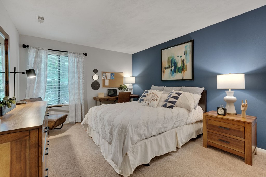 the master bedroom has a blue accent wall and a large bed