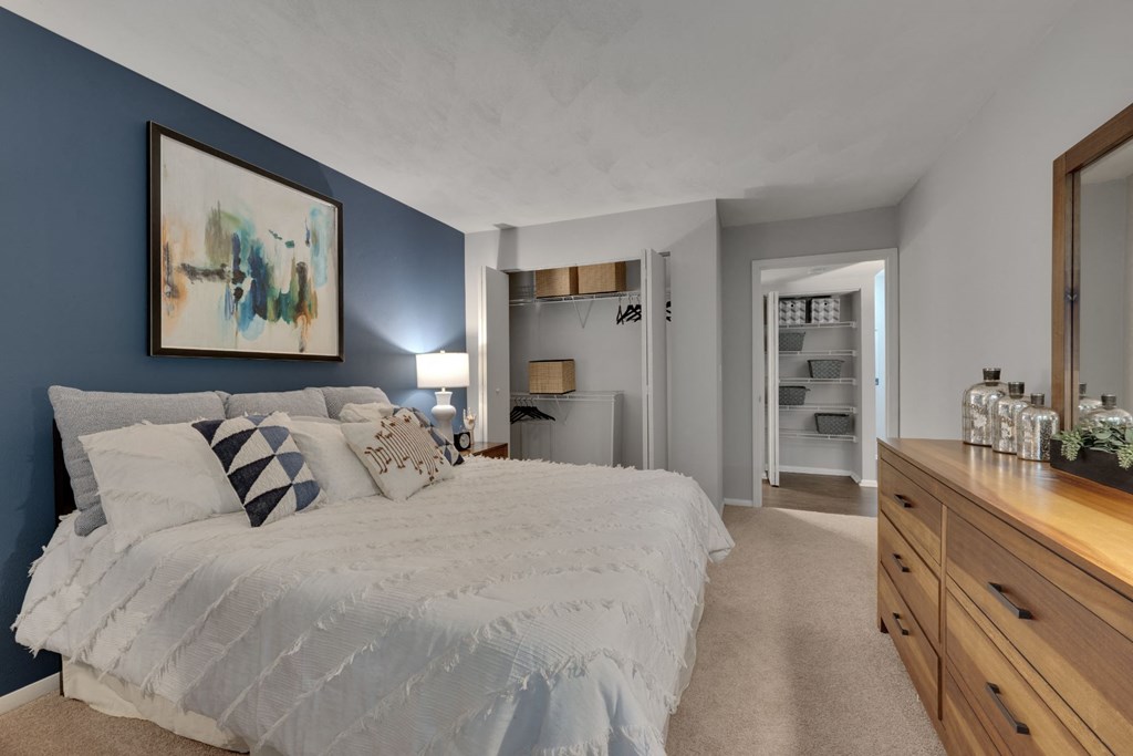 a bedroom with a white bed and a blue accent wall