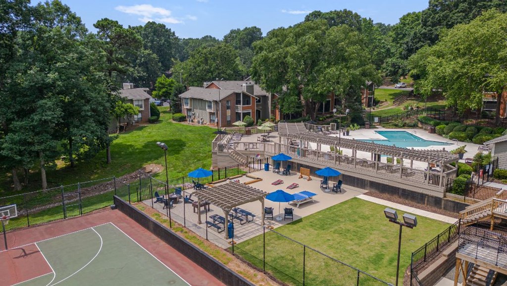 a backyard with a basketball court and a pool and a house