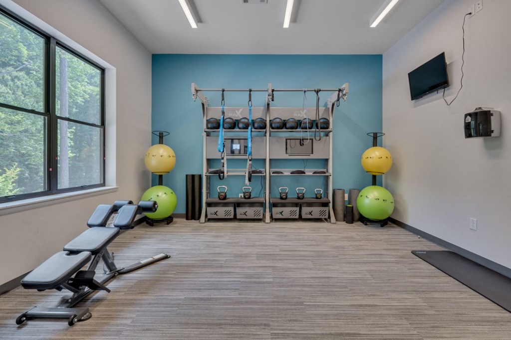 a gym with weights and exercise equipment in a room with a window