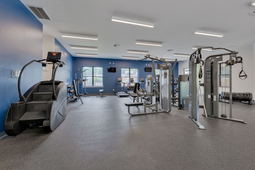 a gym with weights and cardio equipment in a building
