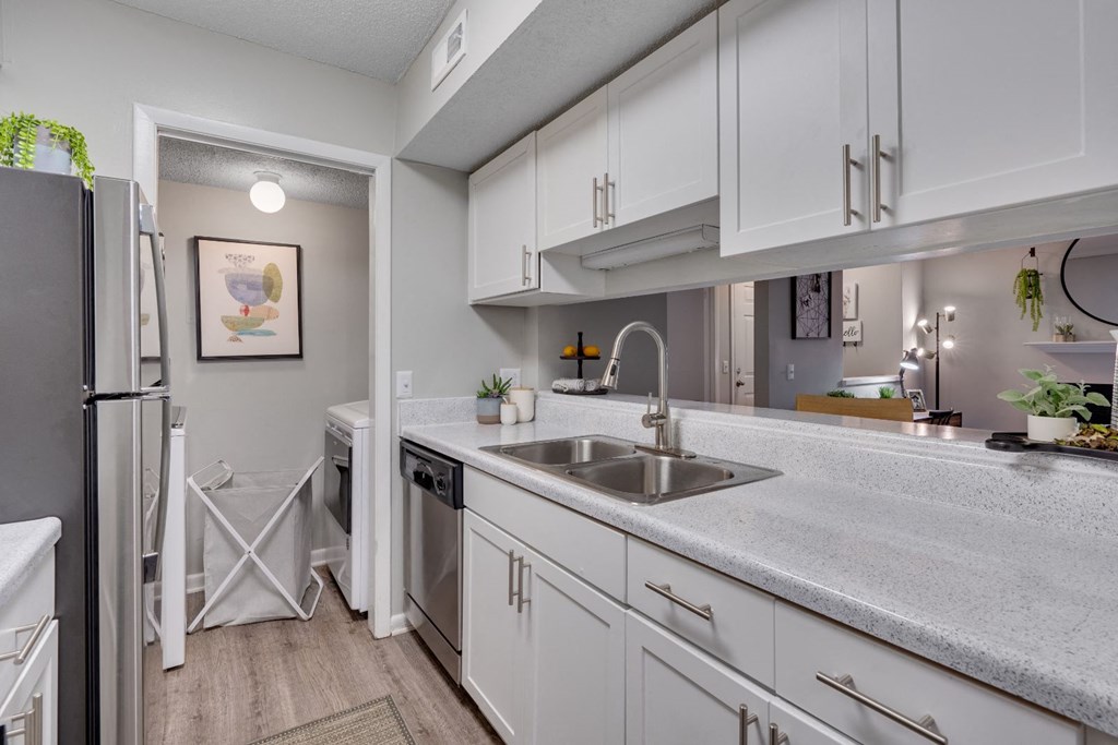 an open kitchen with white cabinets and a stainless steel sink