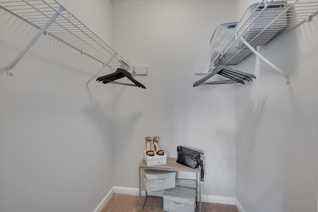 a closet in a room with two shelves and a rack on the wall
