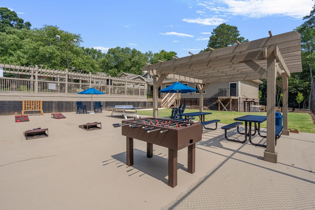 a playground with a foosball table and picnic tables