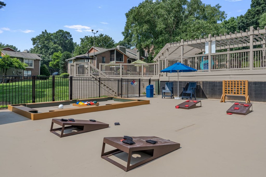 a playground with tables and chairs in a fenced in yard