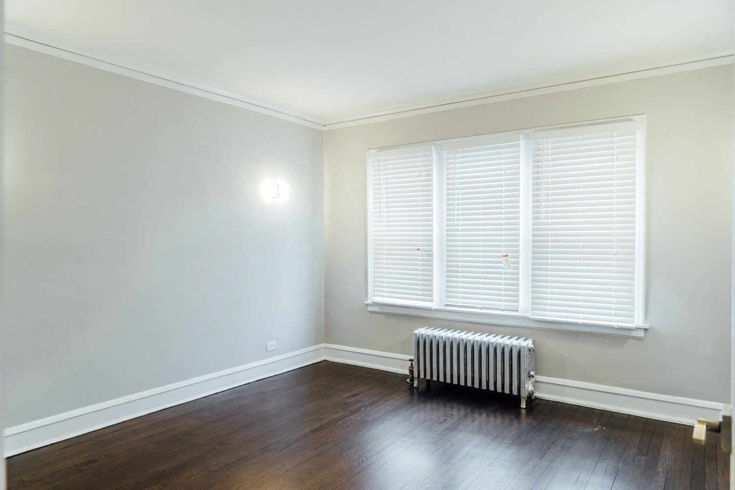 an empty room with a radiator and a window