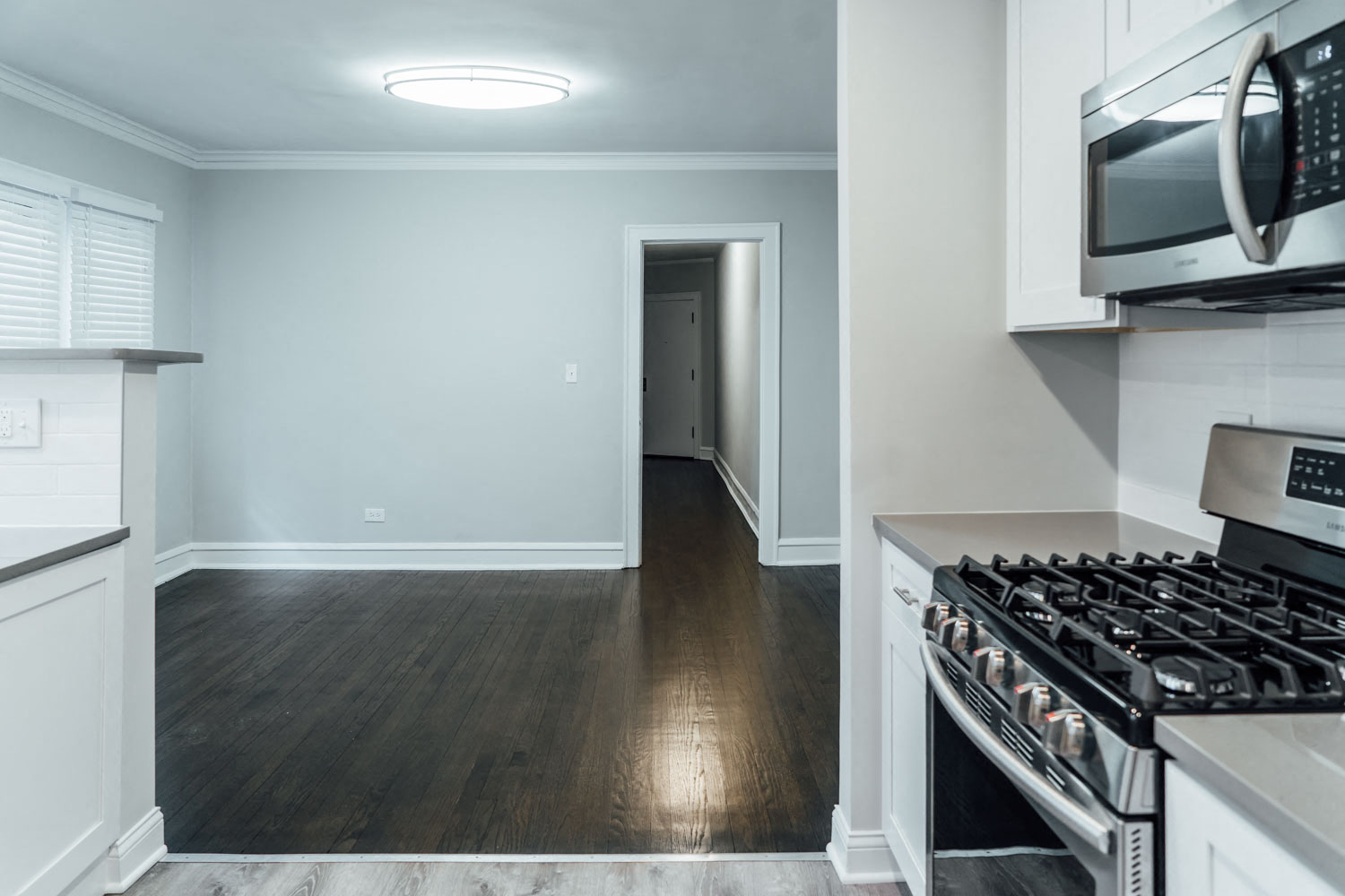 a renovated kitchen with white cabinets and stainless steel appliances