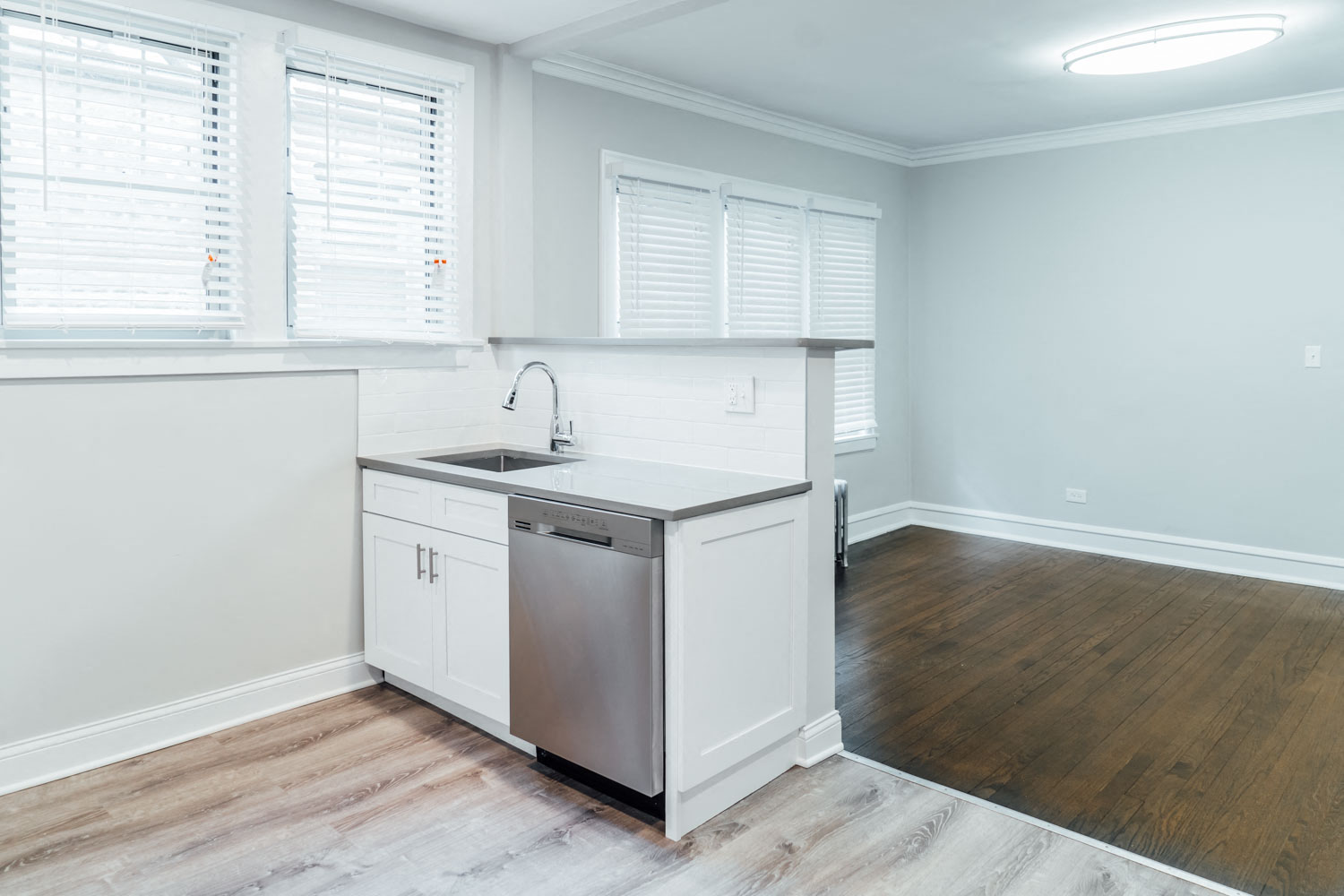 an empty kitchen with a sink and a refrigerator