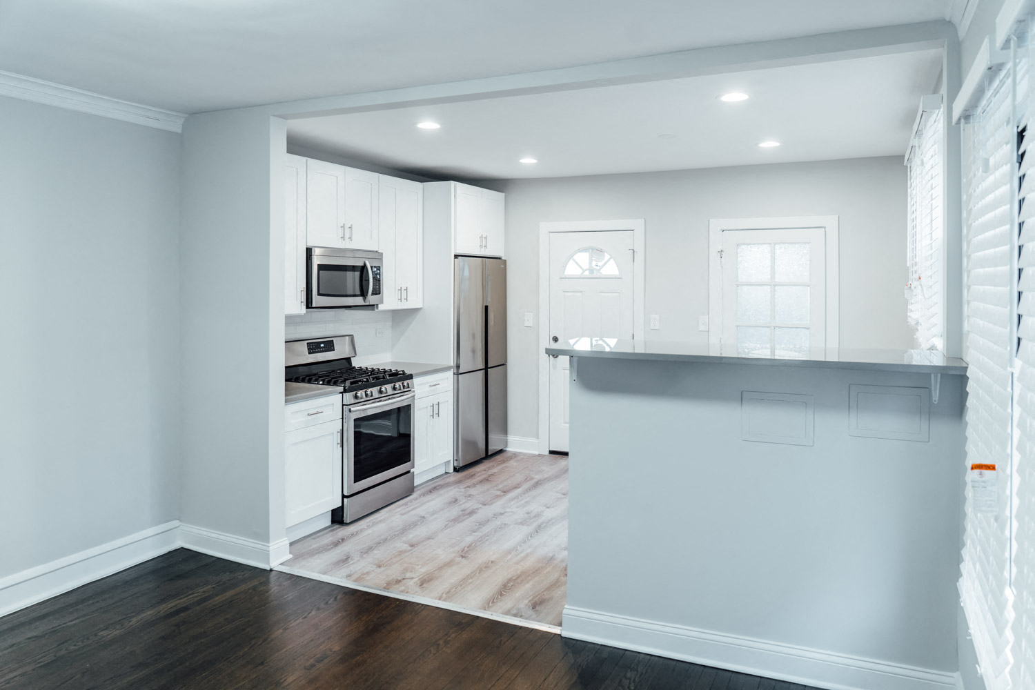 a kitchen with white cabinets and stainless steel appliances
