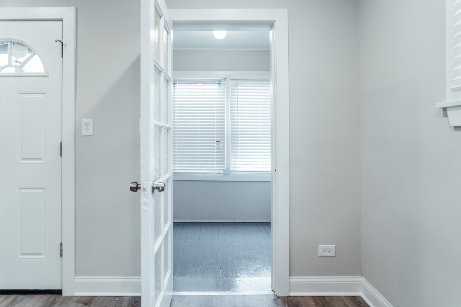 a room with white walls and a white door and a window