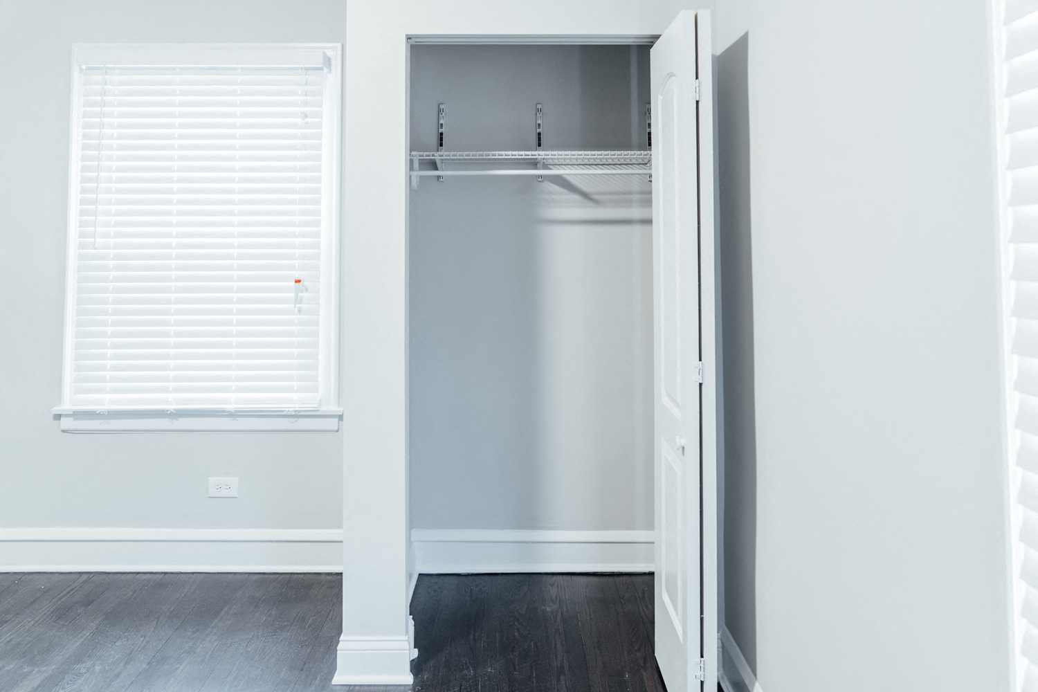 an empty closet in a room with white walls and a window