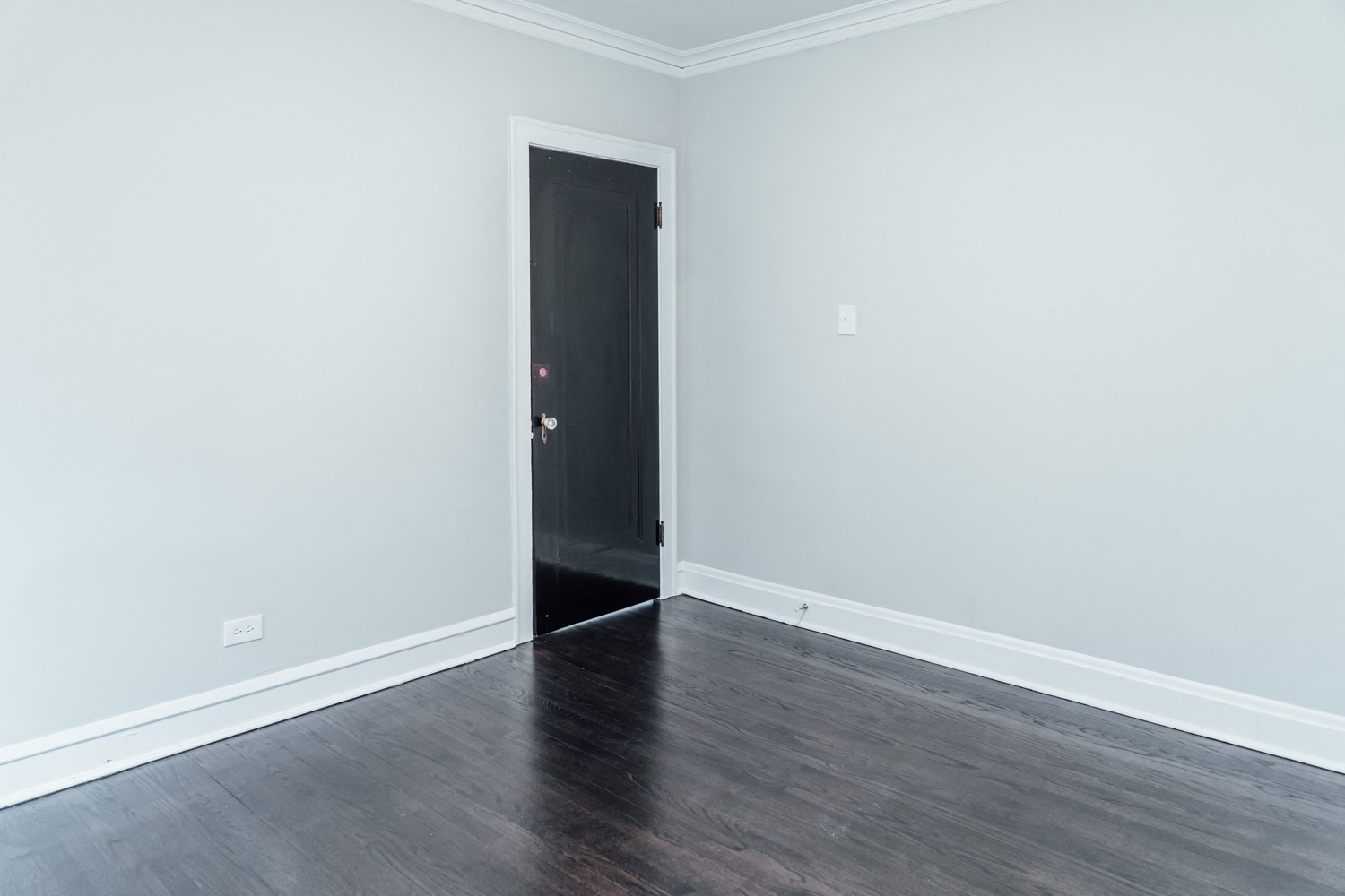an empty room with wood floors and a door