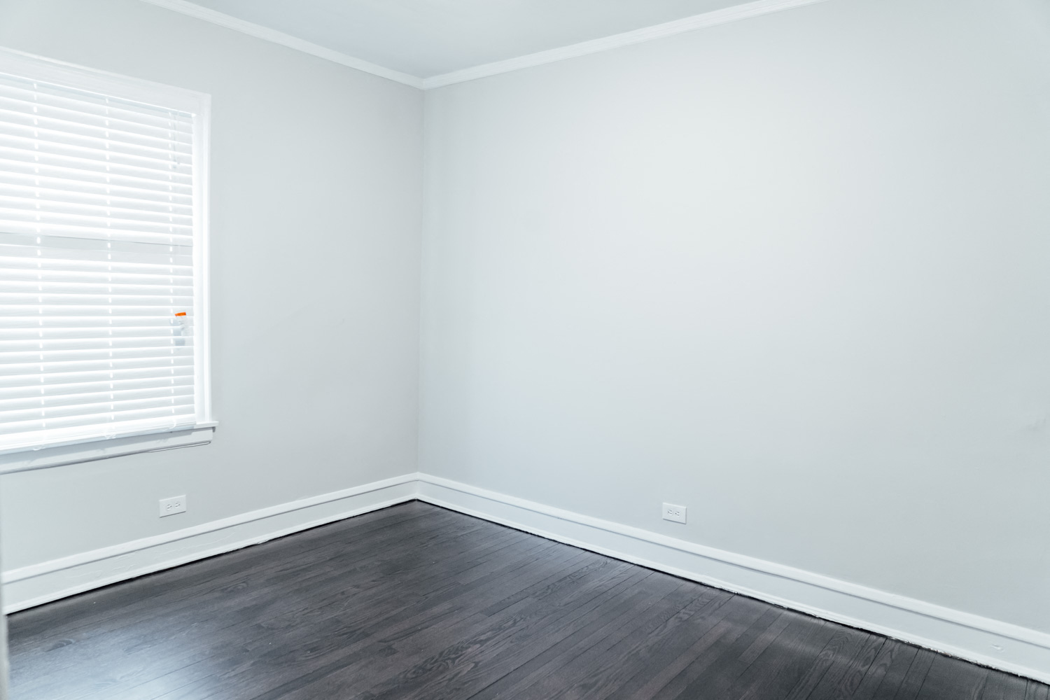 an empty room with wood floors and a window