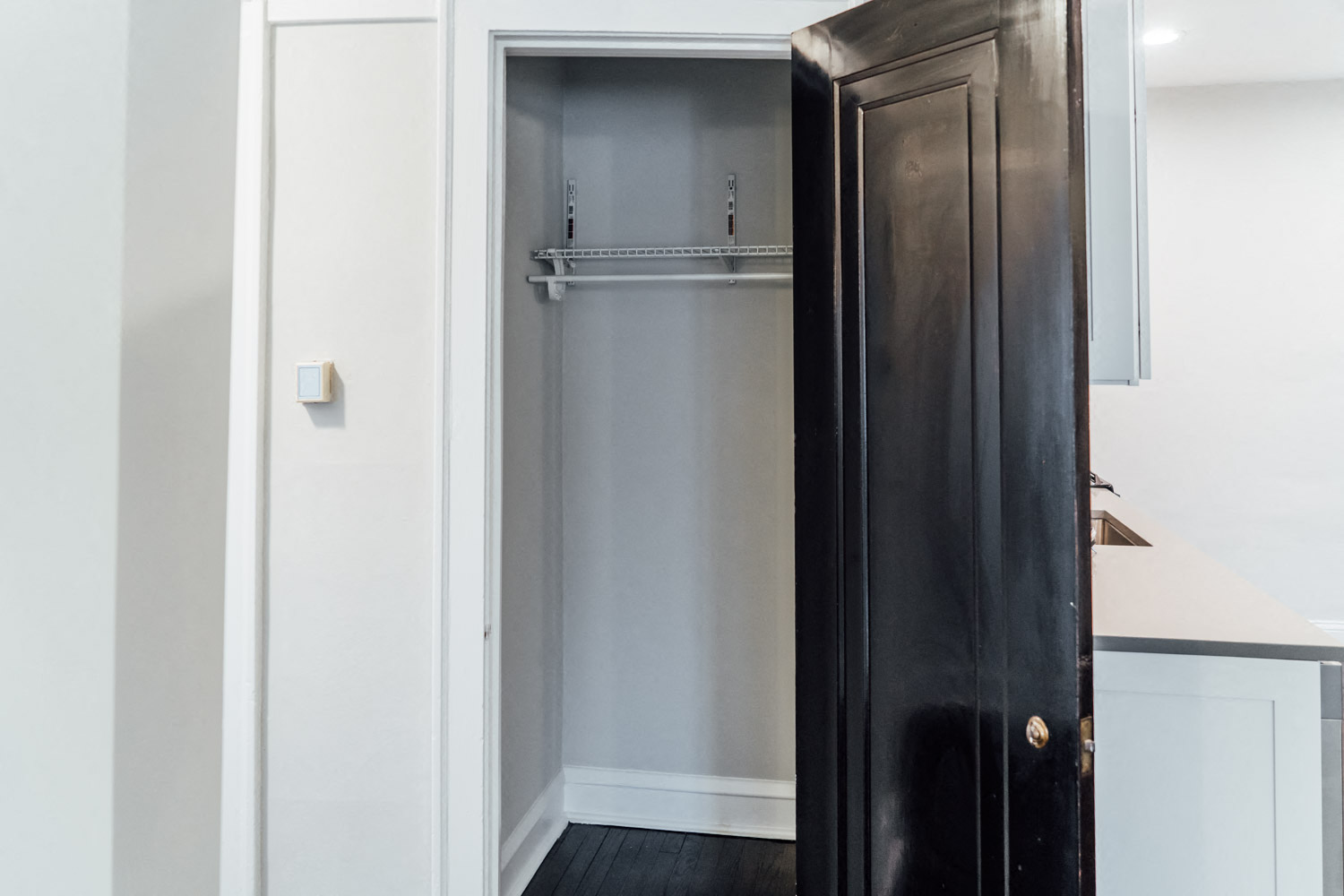 a small closet in a room with a black door