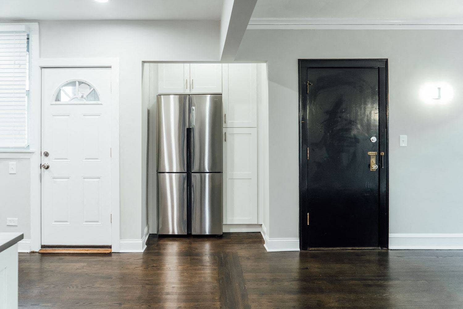 a kitchen with a stainless steel refrigerator and a black door