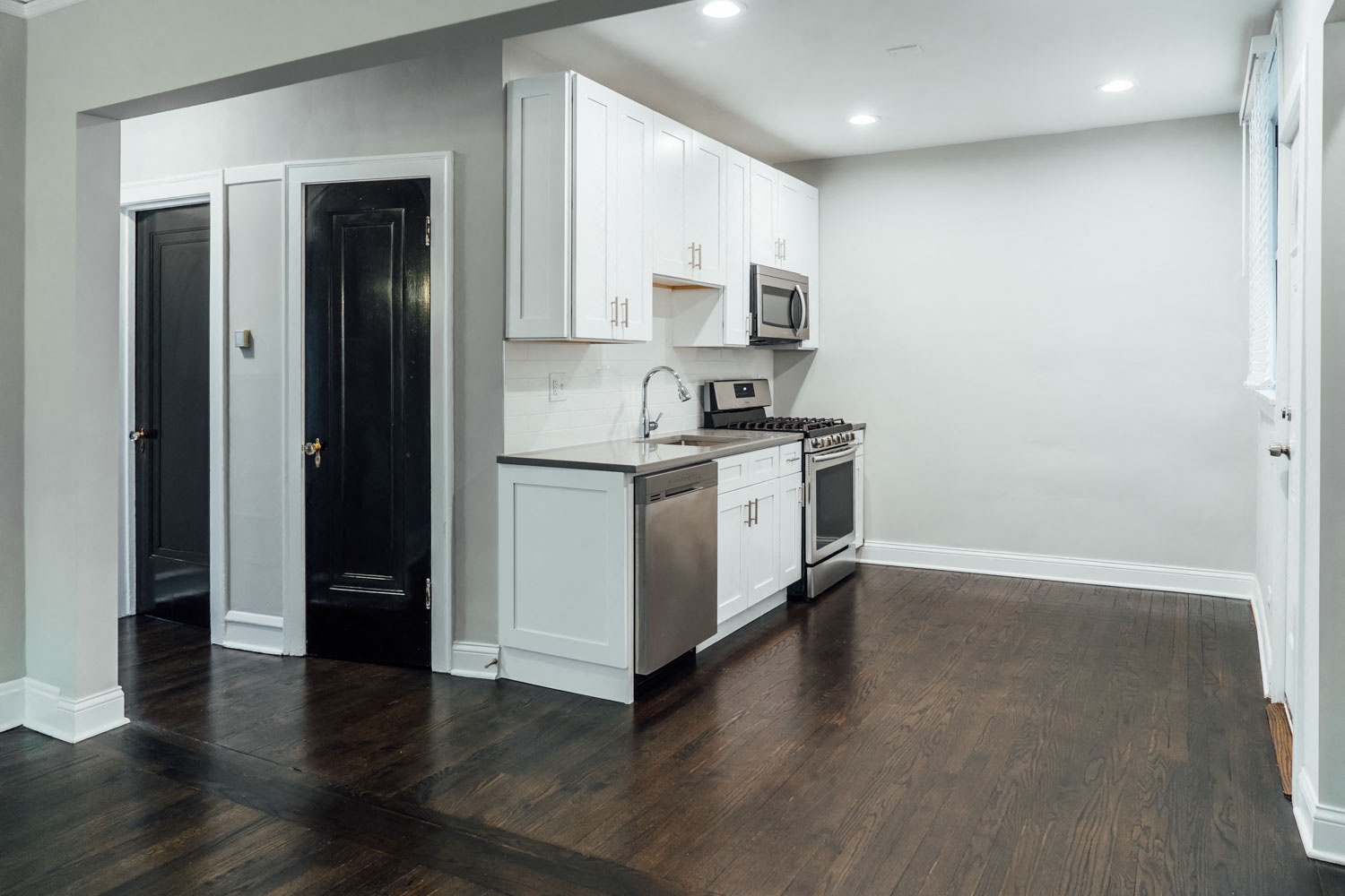 a kitchen with white cabinets and a stove and a refrigerator