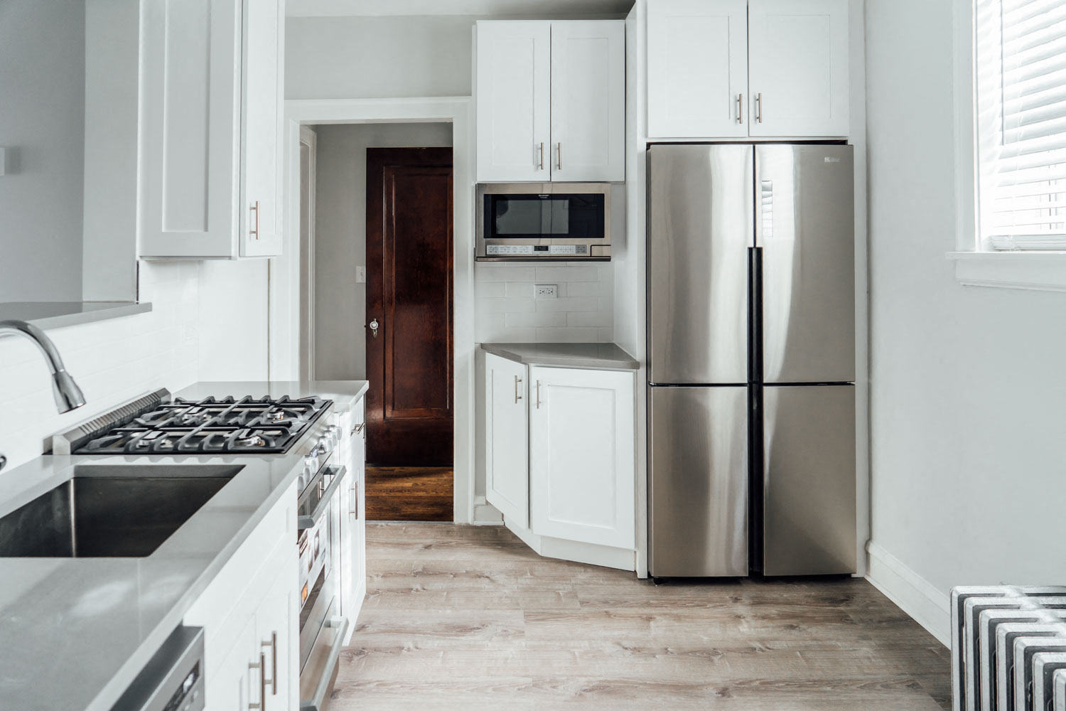 a kitchen with white cabinets and a stainless steel refrigerator