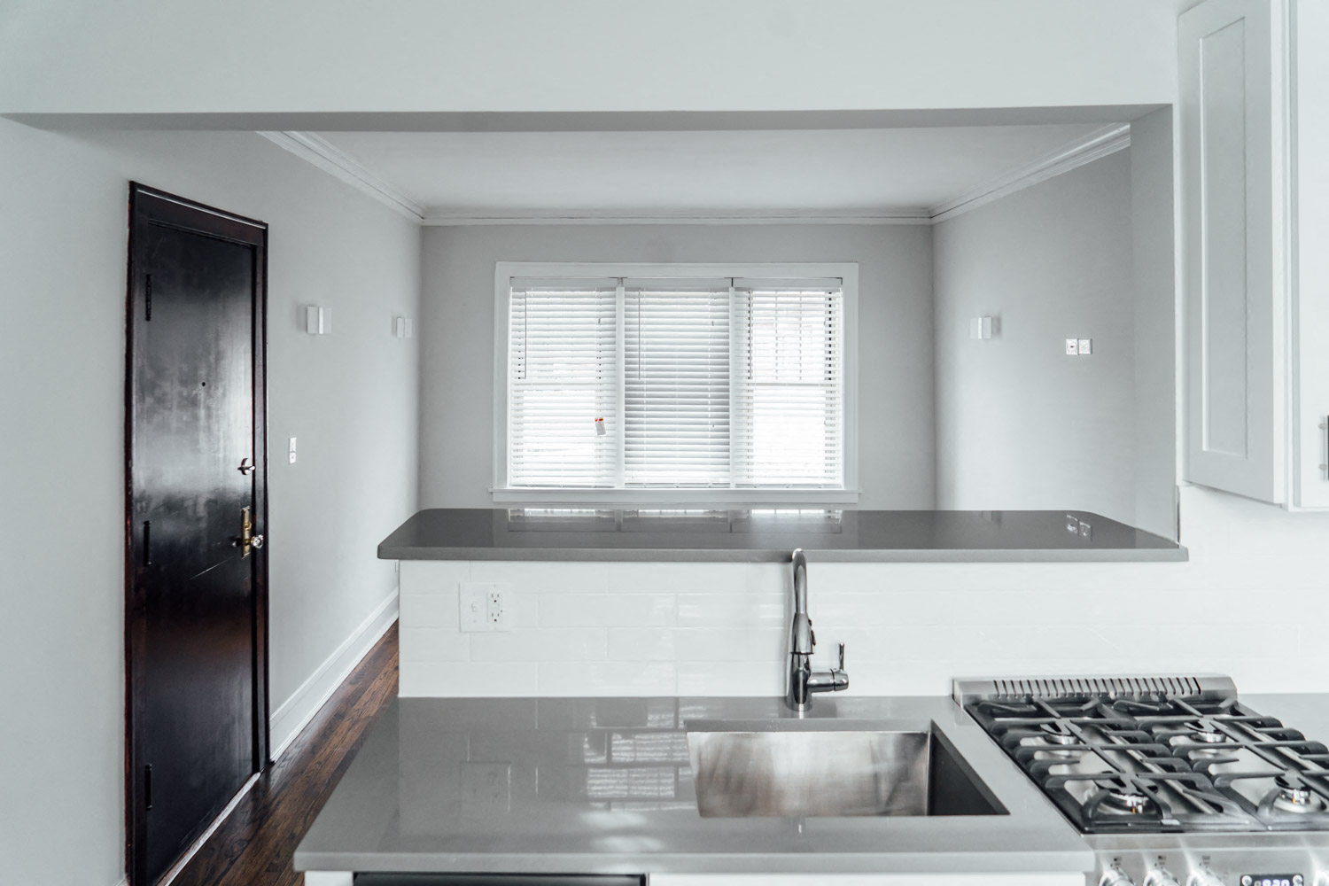 a white kitchen with a sink and a window