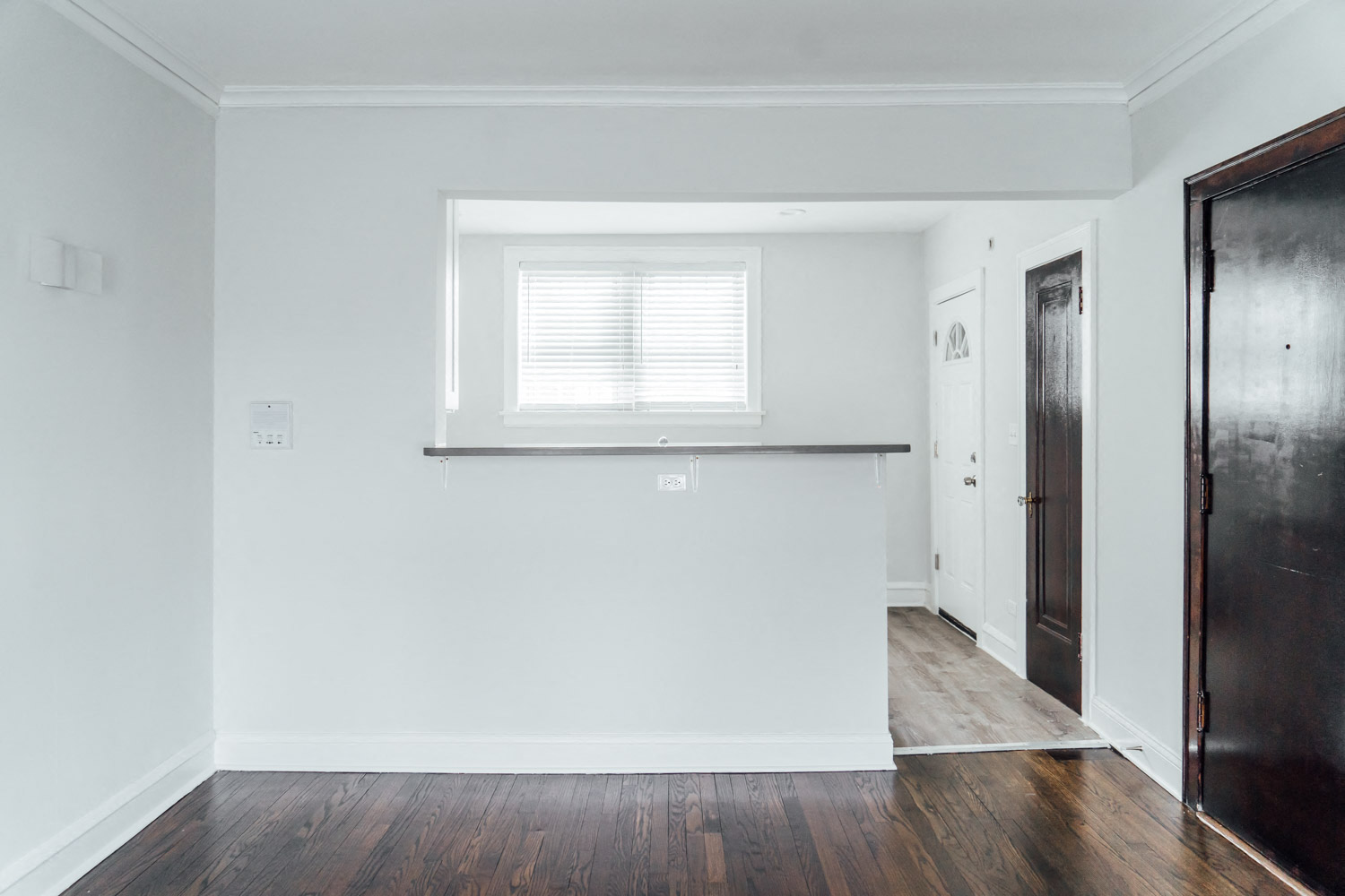 an empty room with white walls and a window
