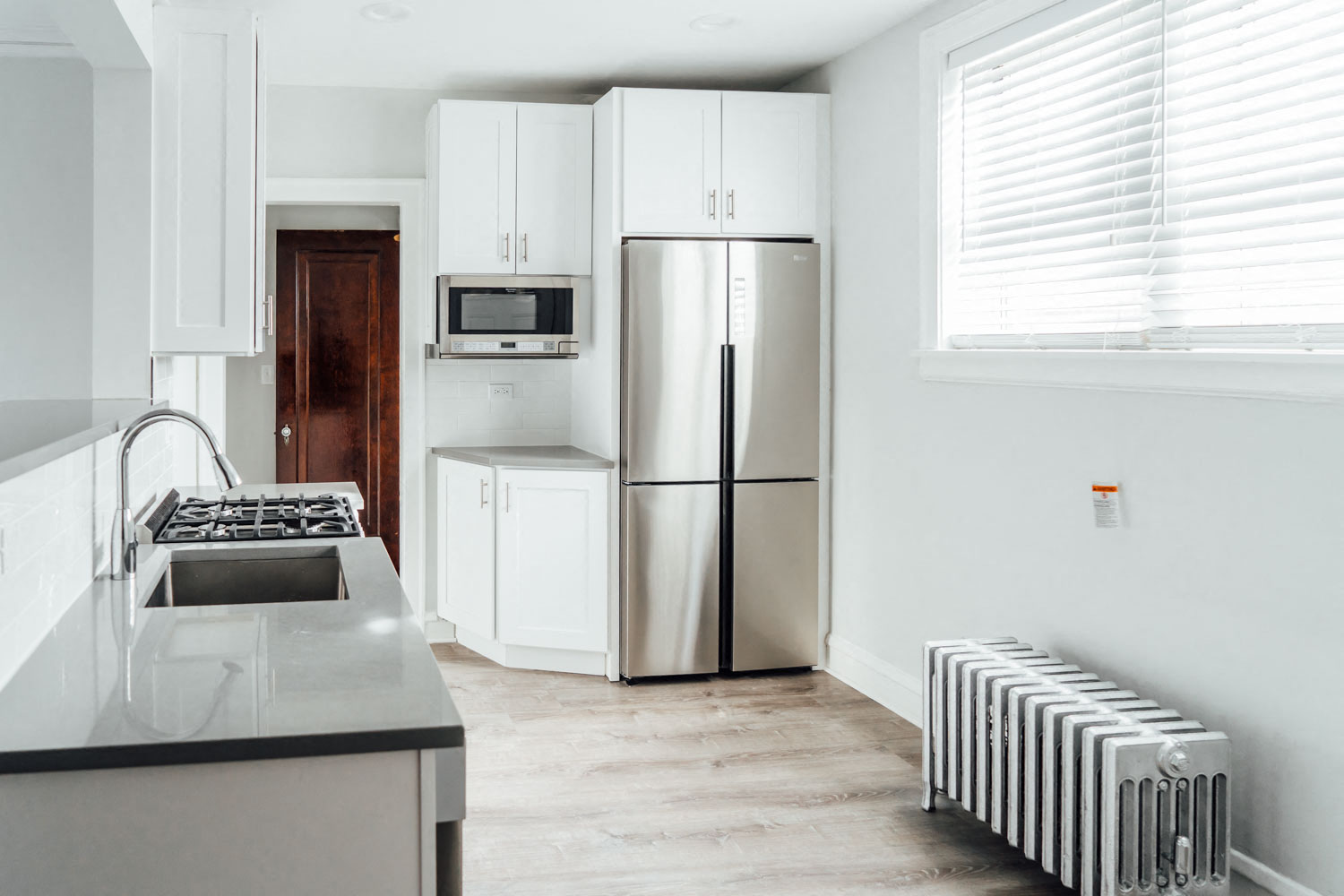 a kitchen with white cabinets and a stainless steel refrigerator