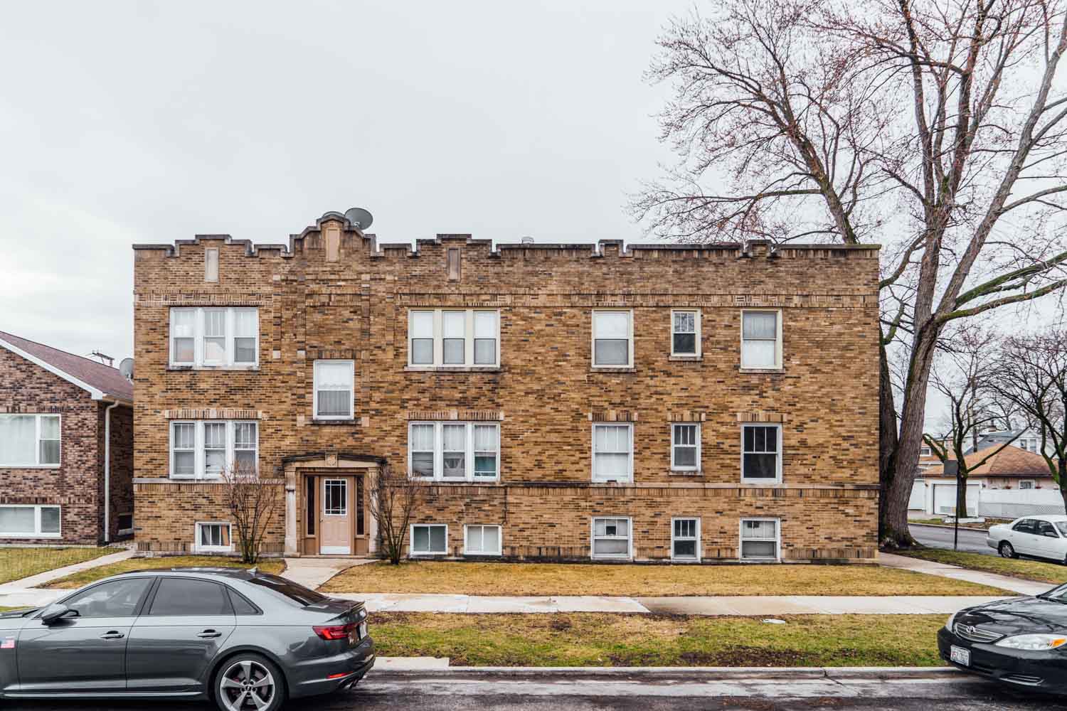 a brick building with cars parked in front of it