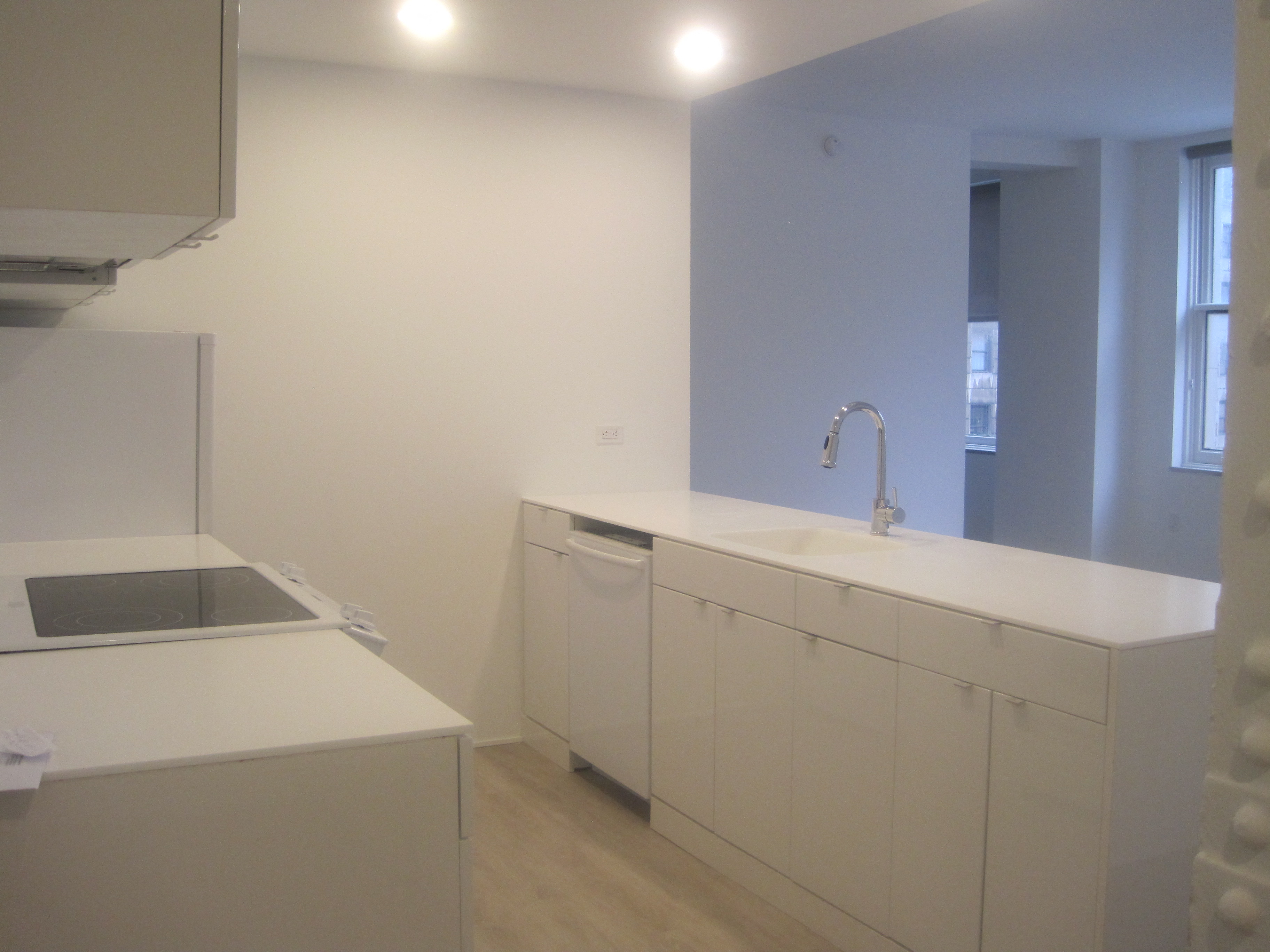 an empty kitchen with white cabinets and a sink