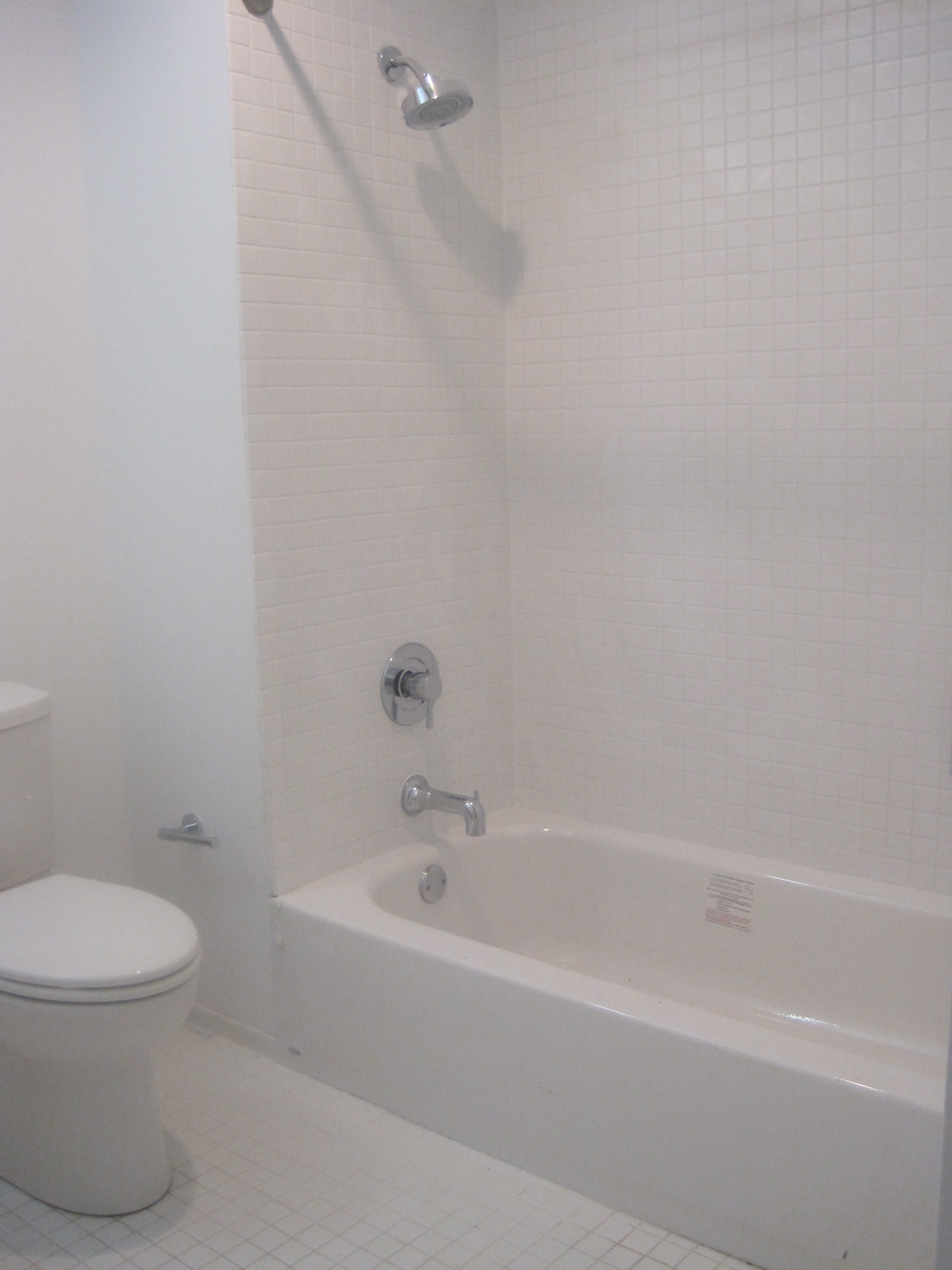 a white bathroom with a tub and a toilet