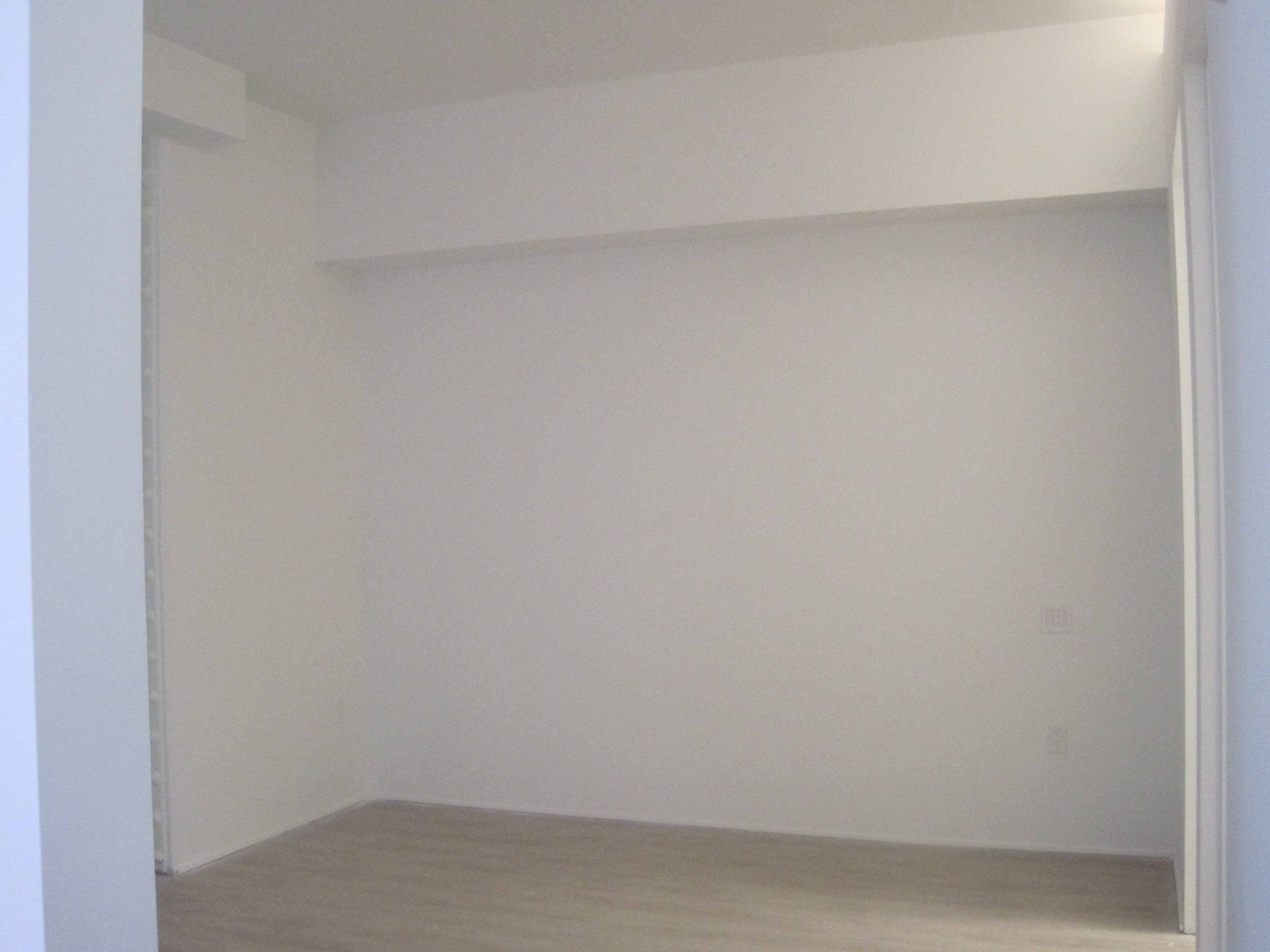 an empty room with white walls and a wood floor