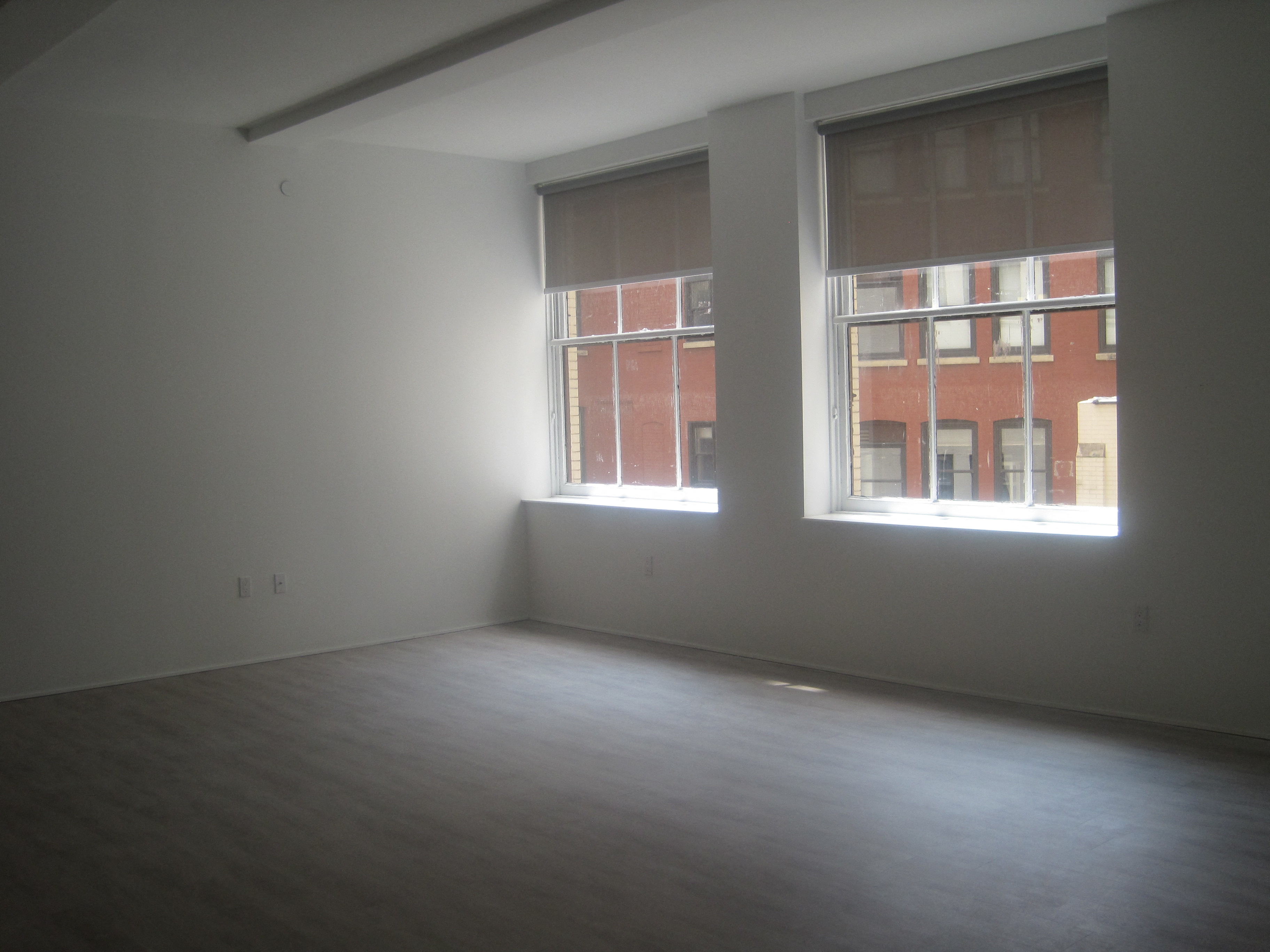 an empty room with two windows in it