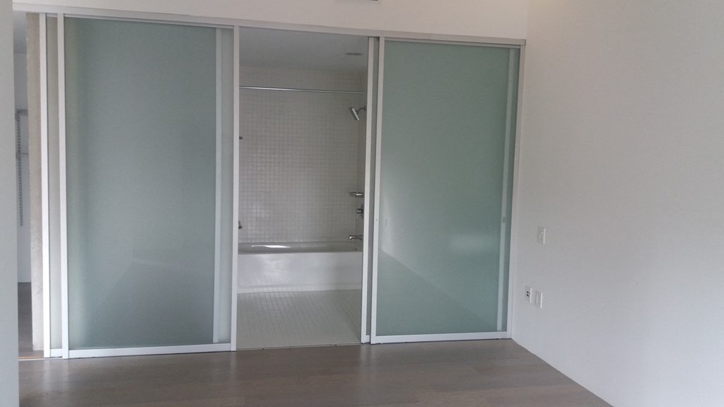 an open sliding glass door leading to a bathroom
