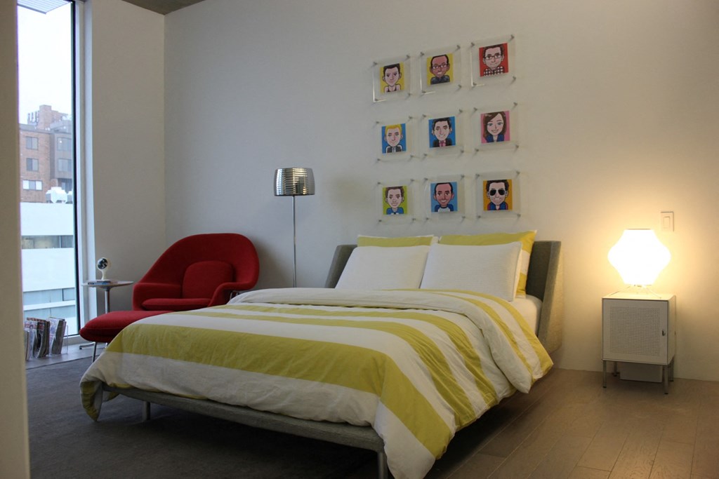 a bedroom with a bed and a chair and a window