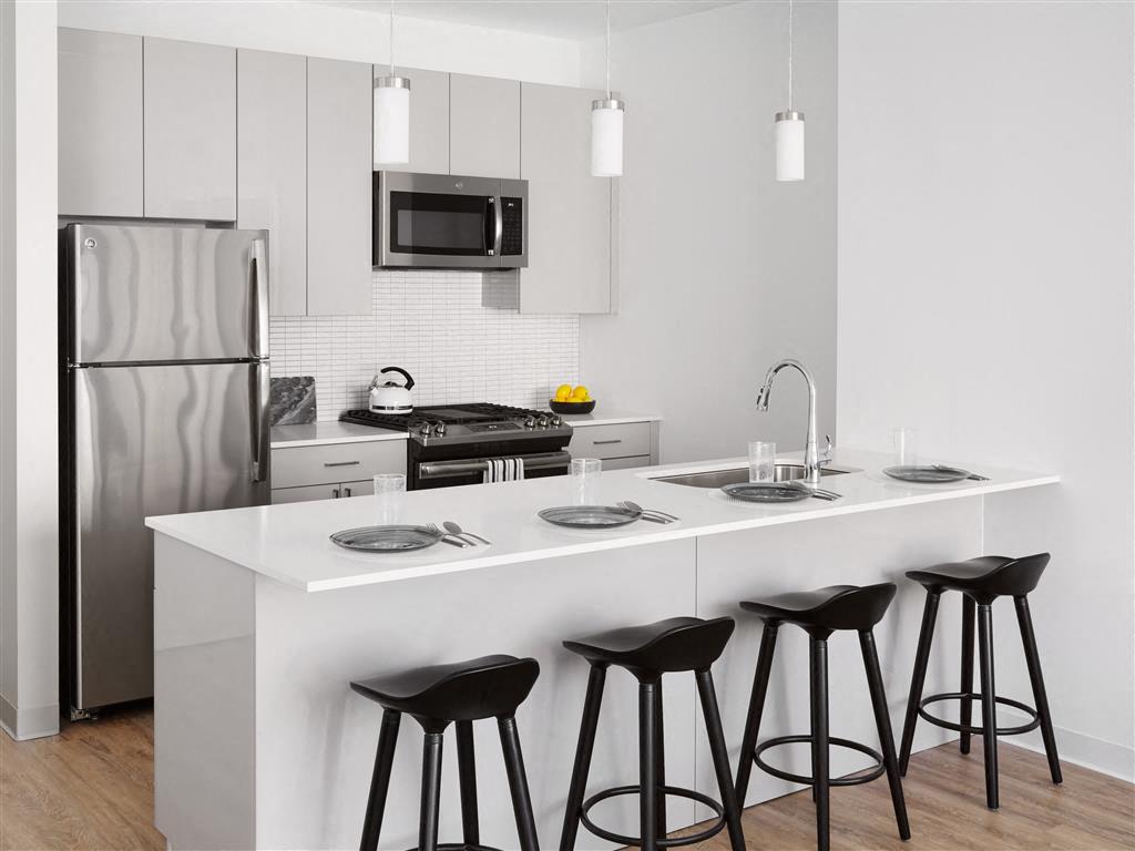 a kitchen with a counter and three bar stools
