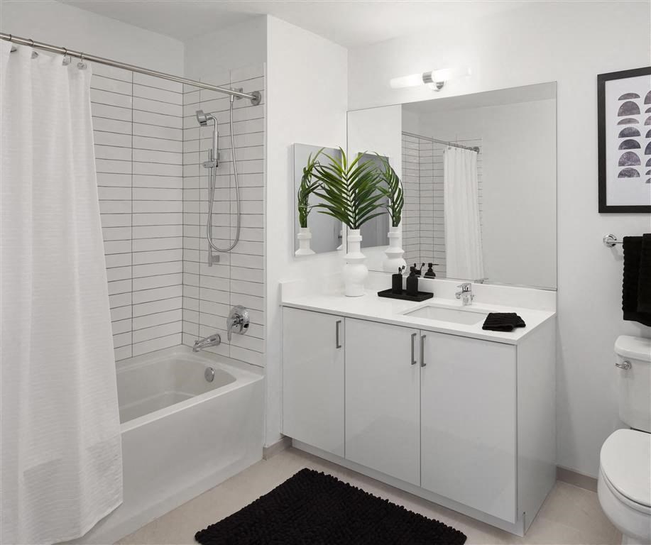 a white bathroom with a sink and a bath tub