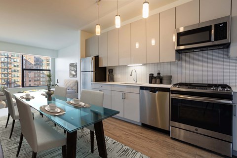 A modern kitchen with a glass dining table and chairs.