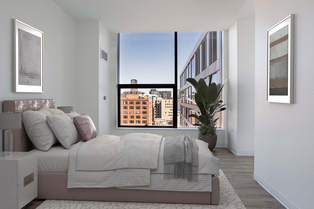 A bedroom with a large bed and a view of the city.