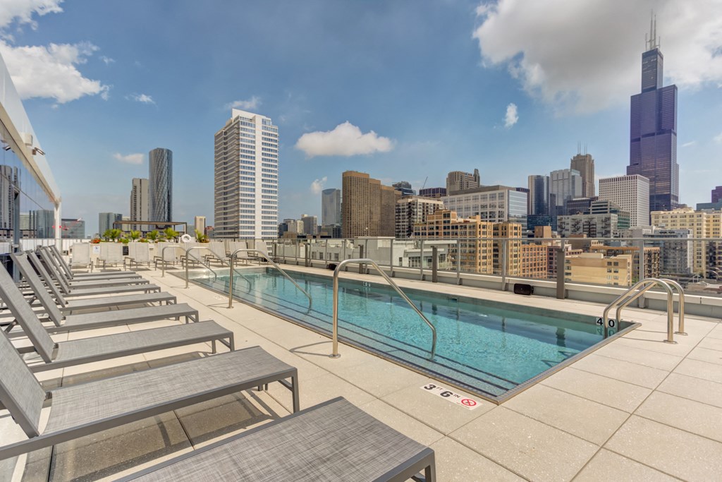 the pool on the rooftop of a building with the city in the background