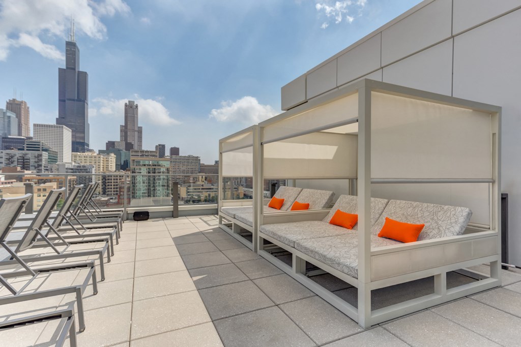 a room with a view of a city and a bed on a balcony