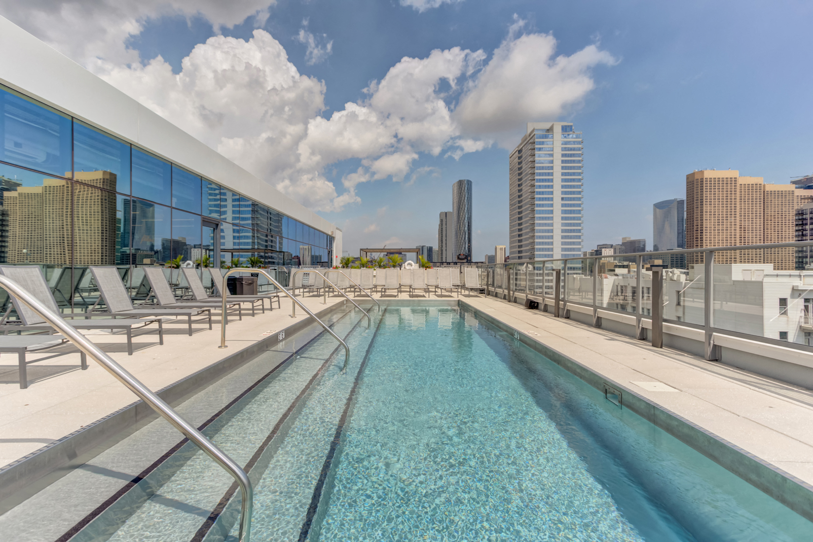 the pool on the rooftop of a building with the city in the background
